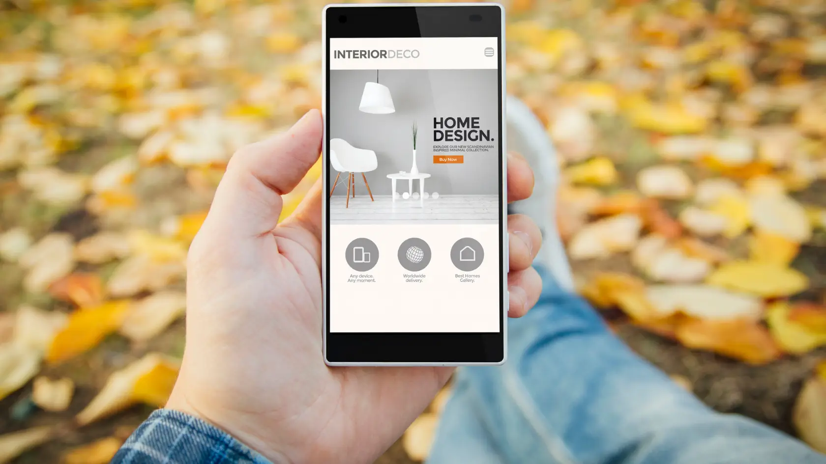 A person holding a smartphone with a fall scene on it.