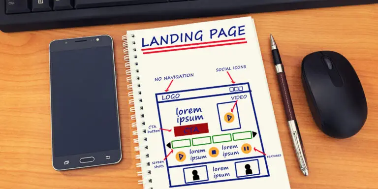 A notebook with the word landing page on it next to a cell phone.