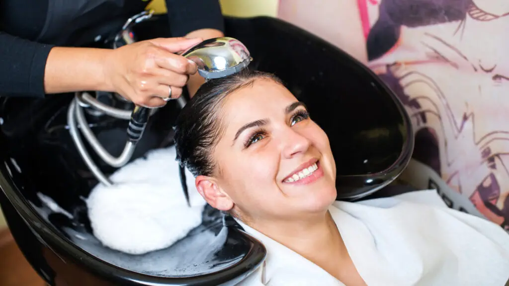A woman getting her hair washed at a salon.