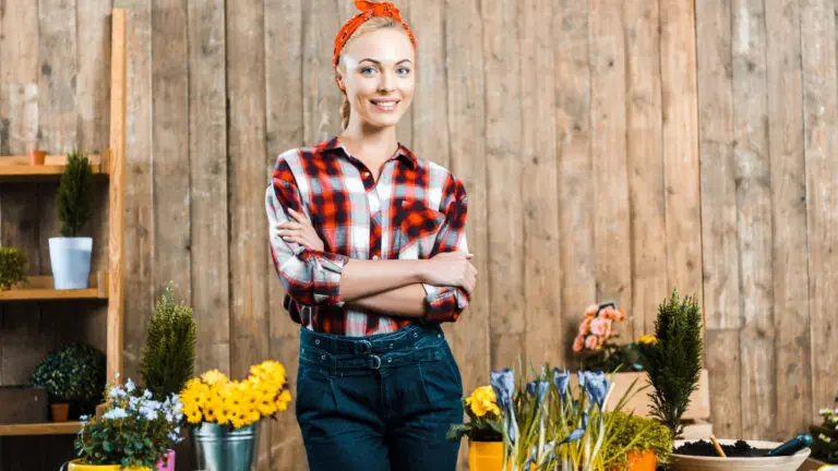 A young woman standing in front of a flower shop.