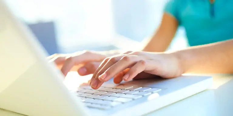 A woman is typing on a laptop computer.