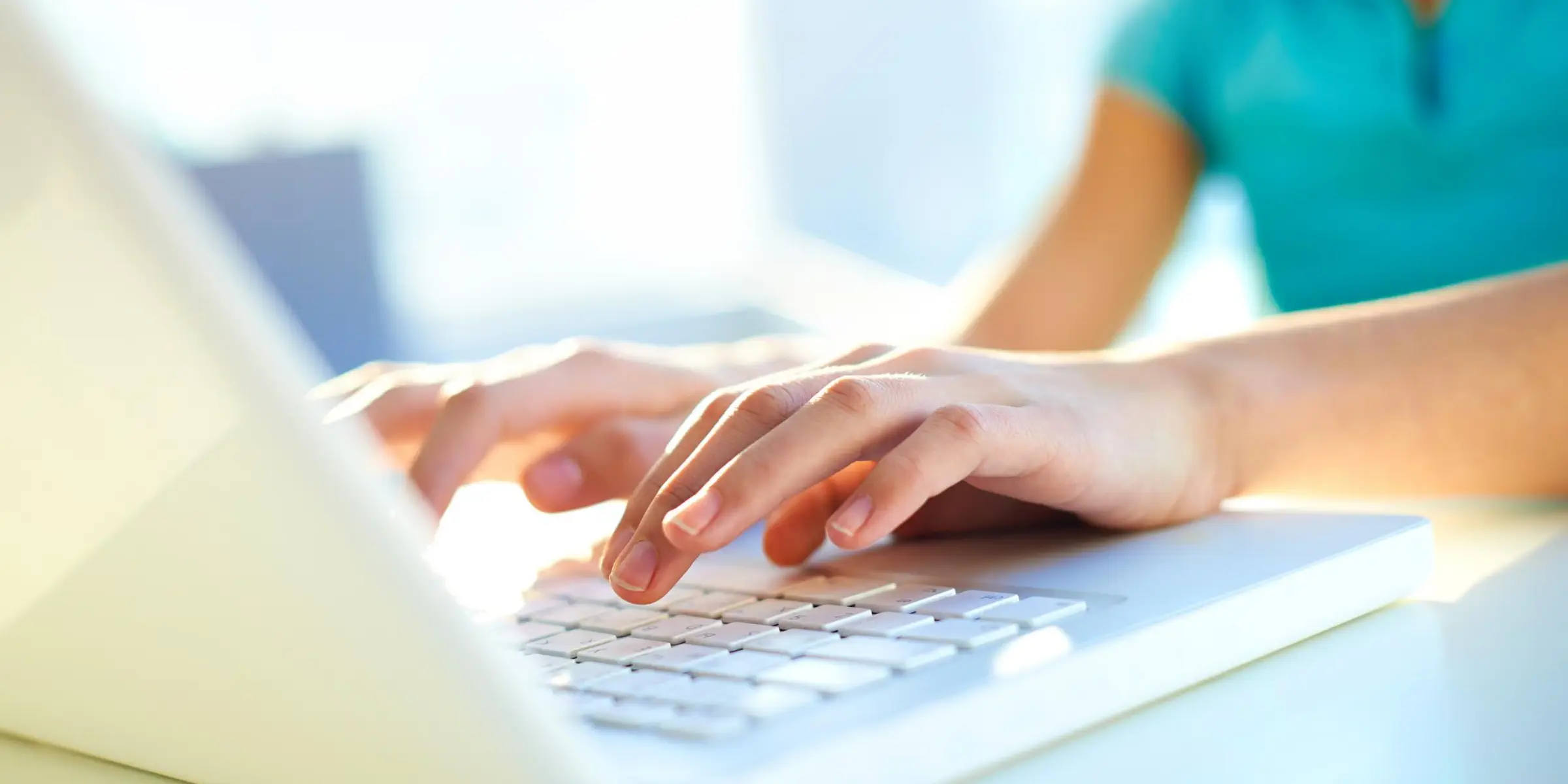 A woman is typing on a laptop computer.