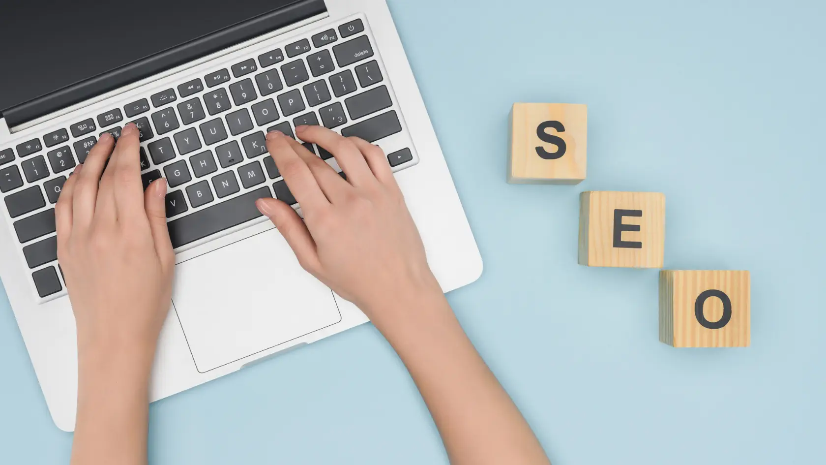 A woman typing on a laptop with the word seo written on it.