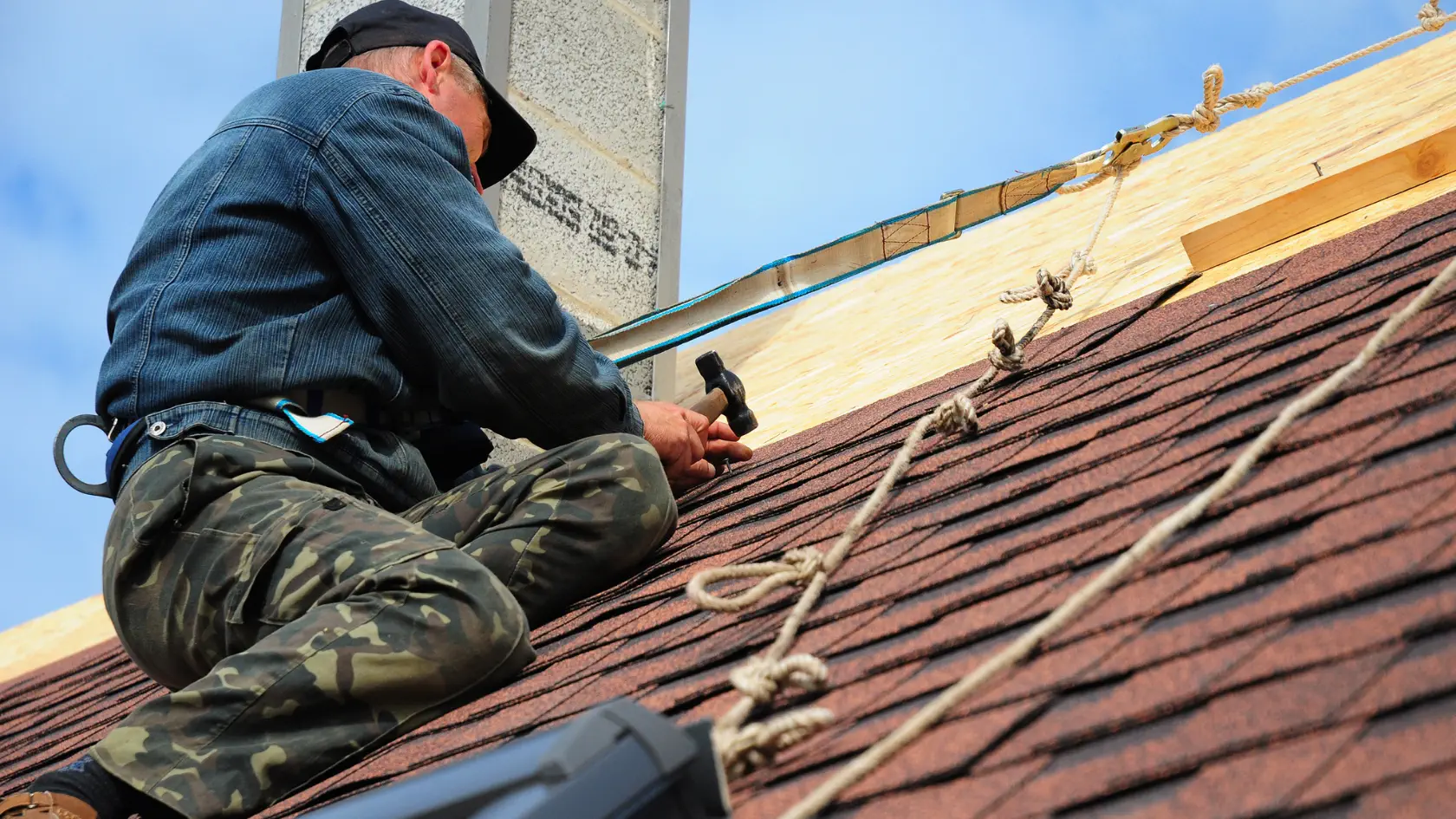 A man working on the roof of a house.
