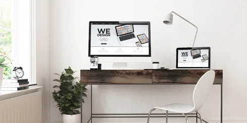 A desk with two monitors and a chair.